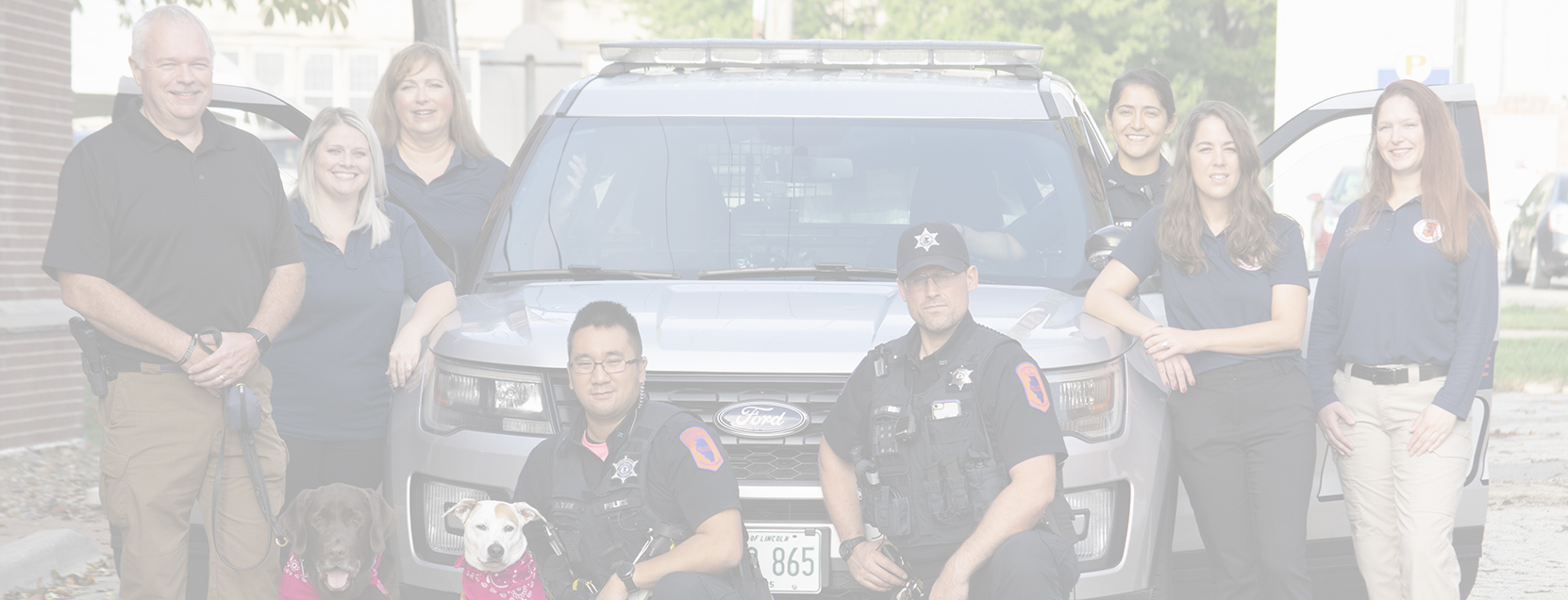 University of Illinois Police staff and comfort K9s positioned in front of a patrol vehicle