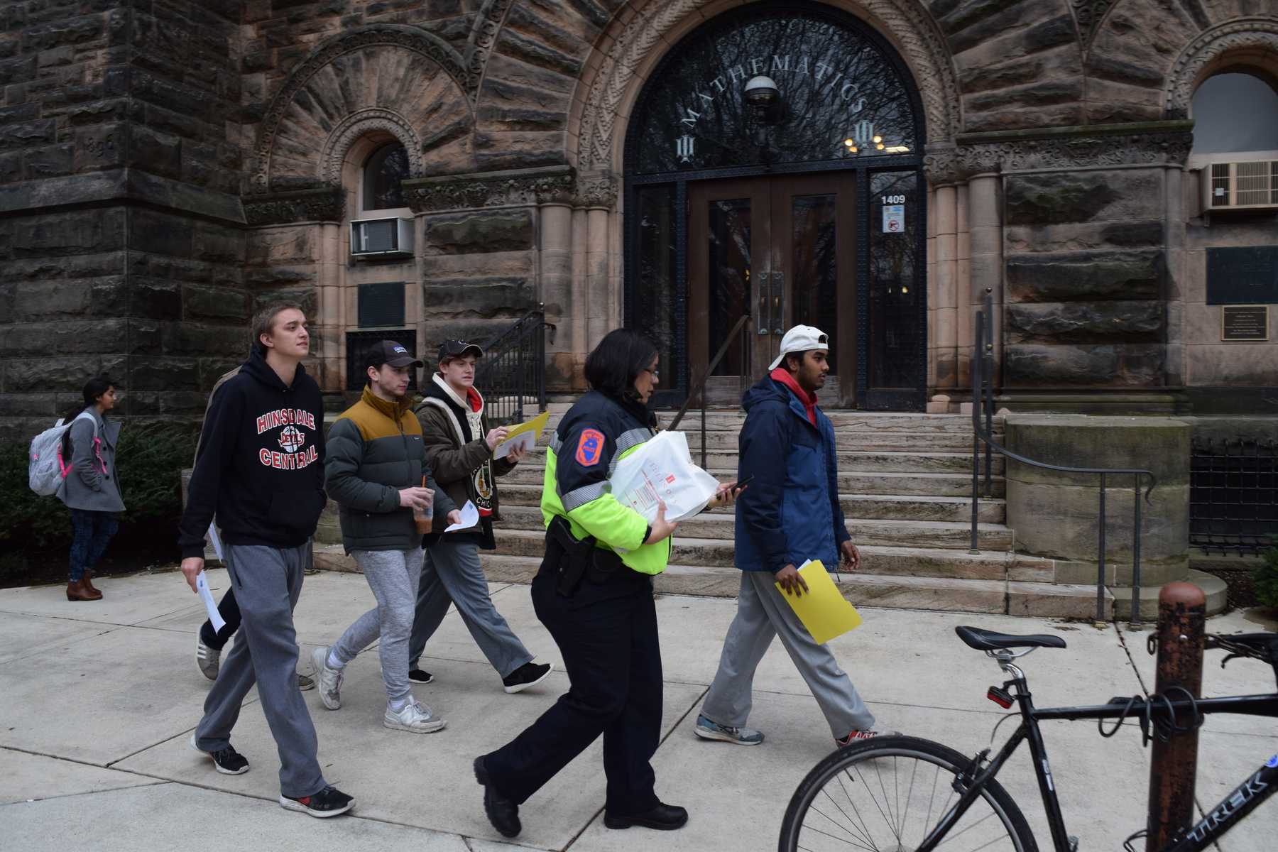 U. of I. Police Lt. Joan Fiesta and members of the Delta Tau Delta fraternity walking together to deliver safety information to students